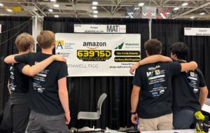 Robotics Team Paragon posing in front of their team's banner.